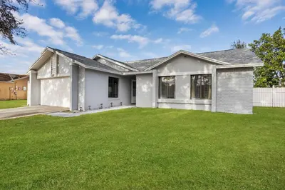 a white house with a green lawn at APluSS Getaway in Kissimmee