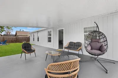 a porch with two chairs and a wicker swing at APluSS Getaway in Kissimmee