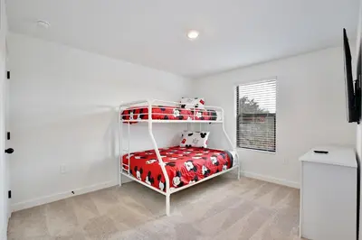 a white bedroom with a bunk bed with a red blanket at Brand new townhouse in The Hub in Kissimmee