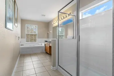 a bathroom with a shower and a glass shower stall at The Colorful Cove in Orlando