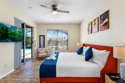 a bedroom with a bed and a ceiling fan at Luxury Emerald Island Resort Villa with Stunning Pool Deck and Lake View Near Disney in Kissimmee