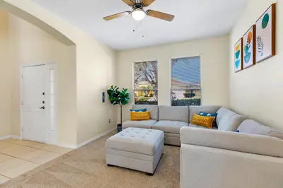 a living room with a couch and a ceiling fan at Luxury Emerald Island Resort Villa with Stunning Pool Deck and Lake View Near Disney in Kissimmee