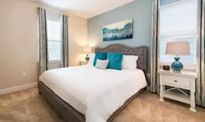 a bedroom with a large white bed with blue pillows at 7412 MA - Stylish Home Near Parks in Orlando