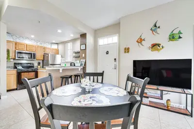 a kitchen and dining room with a table and chairs at 14 Mi to Disney World Kissimmee Condo with Perks! in Kissimmee