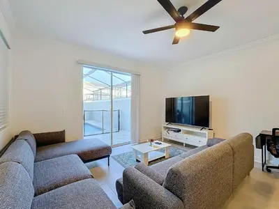 a living room with two couches and a flat screen tv at Incredible Family Retreat with PS5 Private Pool and access to 2 Clubhouses in Kissimmee