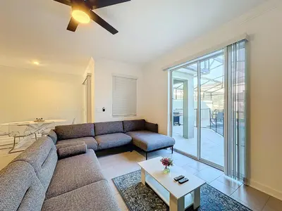 a living room with a couch and a table at Incredible Family Retreat with PS5 Private Pool and access to 2 Clubhouses in Kissimmee