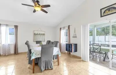 a dining room with a table and a tv at Cozy Home Near Disney With Private Pool in Kissimmee