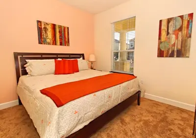 a bedroom with a bed with orange sheets and a window at 17413 Luxury Pool Villa Serenity Haven, 3BR, Balcony in Orlando