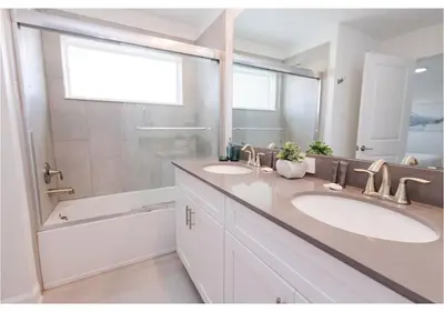 a white bathroom with two sinks and a bath tub at 2489 RT Ultimate Villa Oasis with Pool & Spa Sleeps 13 in Kissimmee