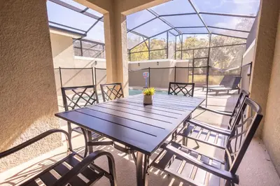 a table and chairs on the balcony of a building at 4BR Villa Private Pool - 11 Guests - Ultimate Family Adventure Awaits in Kissimmee