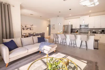 a living room with a white couch and a kitchen at 4BR Villa Private Pool - 11 Guests - Ultimate Family Adventure Awaits in Kissimmee