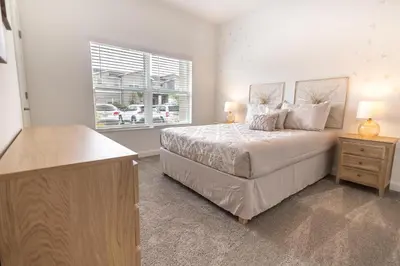 a bedroom with a large bed and a window at 2604 - Luxury 4-BR Villa with Private Pool Retreat in Kissimmee