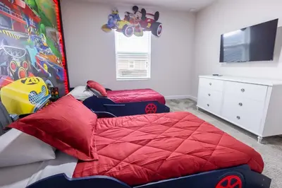 a bedroom with a red bed and a tv at 2901 SS Discover Opulence 4-Bedroom Villa with Pool, and Magical Themed Rooms! in Kissimmee