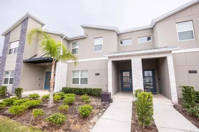 a building with a palm tree in front of it at 2901 SS Discover Opulence 4-Bedroom Villa with Pool, and Magical Themed Rooms! in Kissimmee