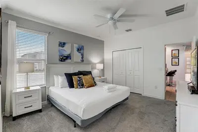 a bedroom with a bed and a ceiling fan at 2940 - Elegant 5BR Villa at Storey Lake Resort Comfort Luxury and Proximity Disney and Universal in Kissimmee