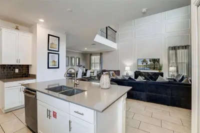 a kitchen and a living room with a couch at 2940 - Elegant 5BR Villa at Storey Lake Resort Comfort Luxury and Proximity Disney and Universal in Kissimmee
