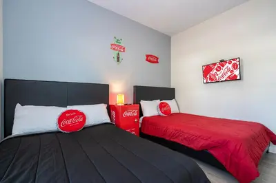 two beds in a room with coca cola signs on the wall at Opulent 5 BR Villa Private Pool - 12 Guests - 3085 TS in Kissimmee