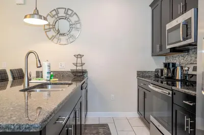 a kitchen with a sink and a microwave at Opulent 5 BR Villa Private Pool - 12 Guests - 3085 TS in Kissimmee