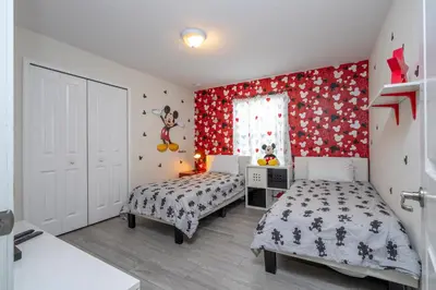 a bedroom with two beds and a red wall at Opulent 5 BR Villa Private Pool - 12 Guests - 3085 TS in Kissimmee