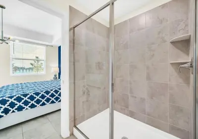 a bathroom with a glass shower and a bed at Luxury 3-Bed Condo in Storey Lake Resort - 3131 in Kissimmee