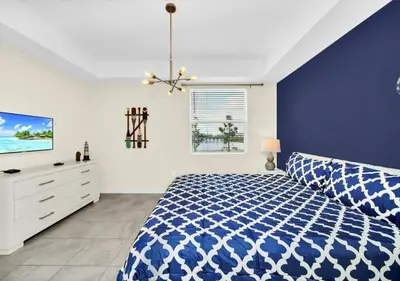 a blue and white bedroom with a bed and a tv at Luxury 3-Bed Condo in Storey Lake Resort - 3131 in Kissimmee