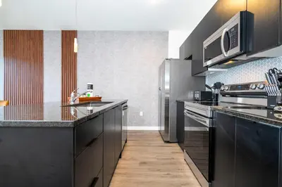 a kitchen with black cabinets and stainless steel appliances at 3258 SW - Luxury Getaway The Hub Relax and Enjoy a Serene Vacation Retreat in Kissimmee
