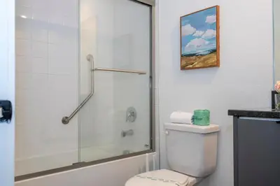 a bathroom with a toilet and a glass shower at 3258 SW - Luxury Getaway The Hub Relax and Enjoy a Serene Vacation Retreat in Kissimmee