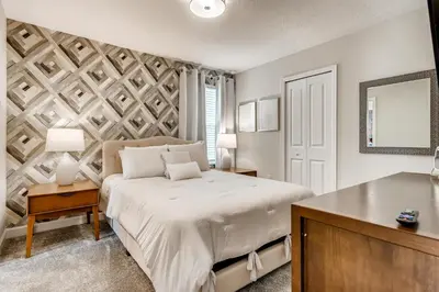 a bedroom with a large bed and a table at Stunning 6BR Home, Private Pool & Spa - 14 Guests - 4507 NL in Kissimmee