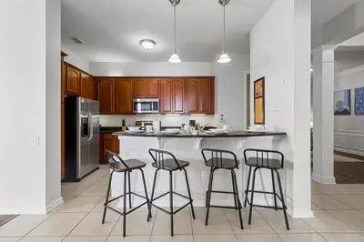a kitchen with three bar stools and a counter at 4816 Cayview Avenue 407 in Orlando
