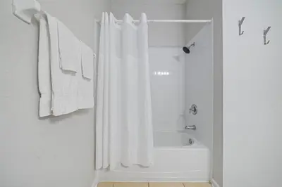 a white bathroom with a shower curtain and a tub at 4816 Cayview Avenue 407 in Orlando