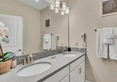 a bathroom with two sinks and a large mirror at Stunning Townhome with Private Pool - Storey Lake - 5021 WW in Kissimmee