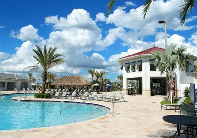 a resort swimming pool with chairs and a building at Stunning Townhome with Private Pool - Storey Lake - 5021 WW in Kissimmee