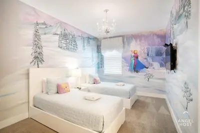 a bedroom with two beds and a wall with a snow scene at Palatial 9BR Private Pool Villa Theater Game Room in Orlando