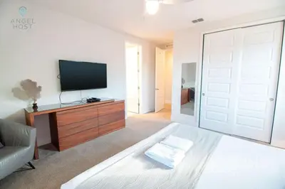 a living room with a tv and a bed and a sliding door at Palatial 9BR Private Pool Villa Theater Game Room in Orlando
