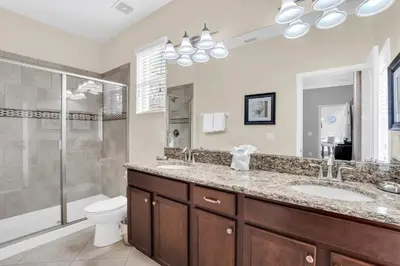 a bathroom with a sink and a shower and a toilet at 9008 Paradise Palms Blissful Haven 5-Bed Oasis of Luxury and Tranquility in Orlando