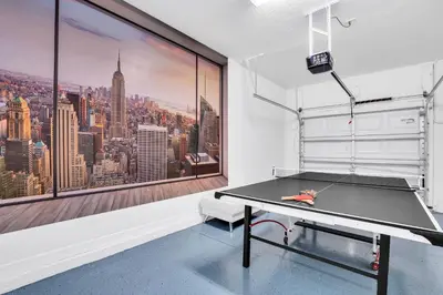 a ping pong table in a room with a large window at 9008 Paradise Palms Blissful Haven 5-Bed Oasis of Luxury and Tranquility in Orlando