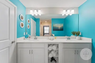 a bathroom with two sinks and a blue wall at Modern Storey Lake Resort Disney Orlando 3120-105 in Kissimmee