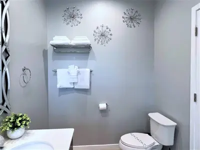 a bathroom with a white toilet and towels on the wall at Resort Home near Disney Themed Jacuzzi Pool 2609 in Orlando