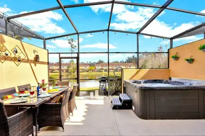 a patio with a bar and a kitchen with a large window at Resort Home near Disney Themed Jacuzzi Pool 2609 in Orlando