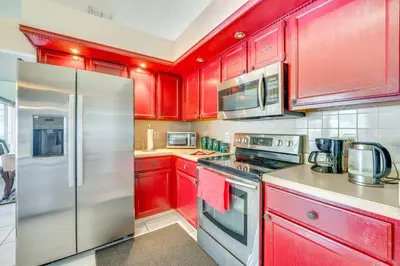 a kitchen with red cabinets and a stainless steel refrigerator at Furnished Lanai and Lake View Quiet Home in Orlando in Kissimmee