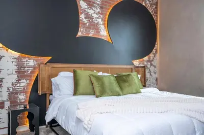 a bedroom with a bed with white sheets and green pillows at The Mouse PlayHouse in Orlando