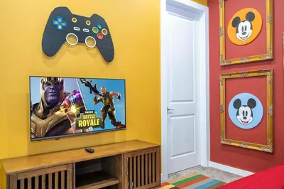 a room with a tv and a video game controller at The Mouse PlayHouse in Orlando