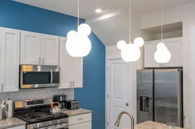a kitchen with white cabinets and silver appliances at The Mouse PlayHouse in Orlando