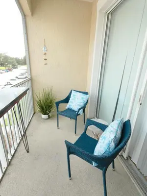 two chairs sitting on the balcony of a building at Beautiful Apartment Near Disney in Kissimmee