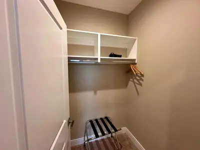a room with a staircase with a chair and a cabinet at Luxury Home 7 Min Disney Universal 3BR4BA - Hot Tub in Orlando