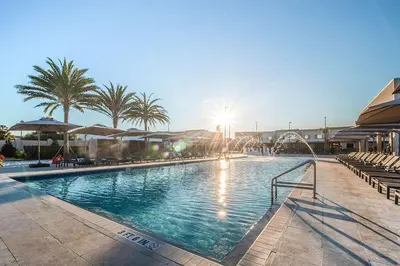 a large swimming pool with palm trees and umbrellas at Luxury Home 7 Min Disney Universal 3BR4BA - Hot Tub in Orlando