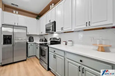 a kitchen with white cabinets and stainless steel appliances at The epic Orlando Vista Cay in Orlando