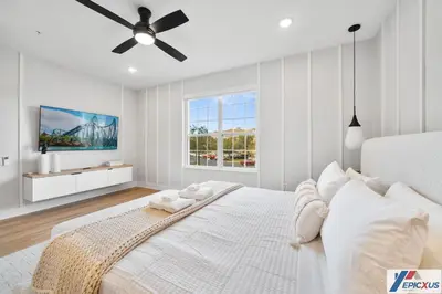 a white bedroom with a bed and a ceiling fan at The epic Orlando Vista Cay in Orlando