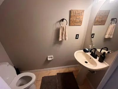 a bathroom with a toilet and a sink at Charming Family Friendly Home in Kissimmee