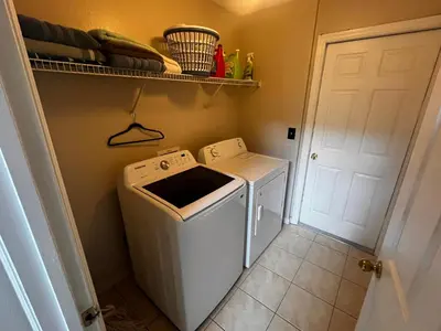 a washer and dryer in a small laundry room at Charming Family Friendly Home in Kissimmee